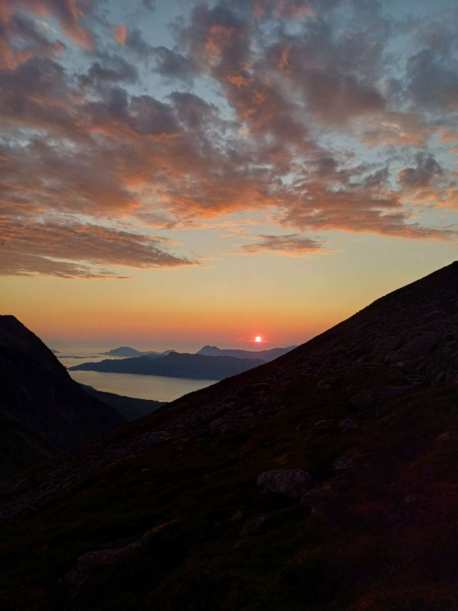 Solnedgang over fjorden sett frå fjellet ved Øggarden